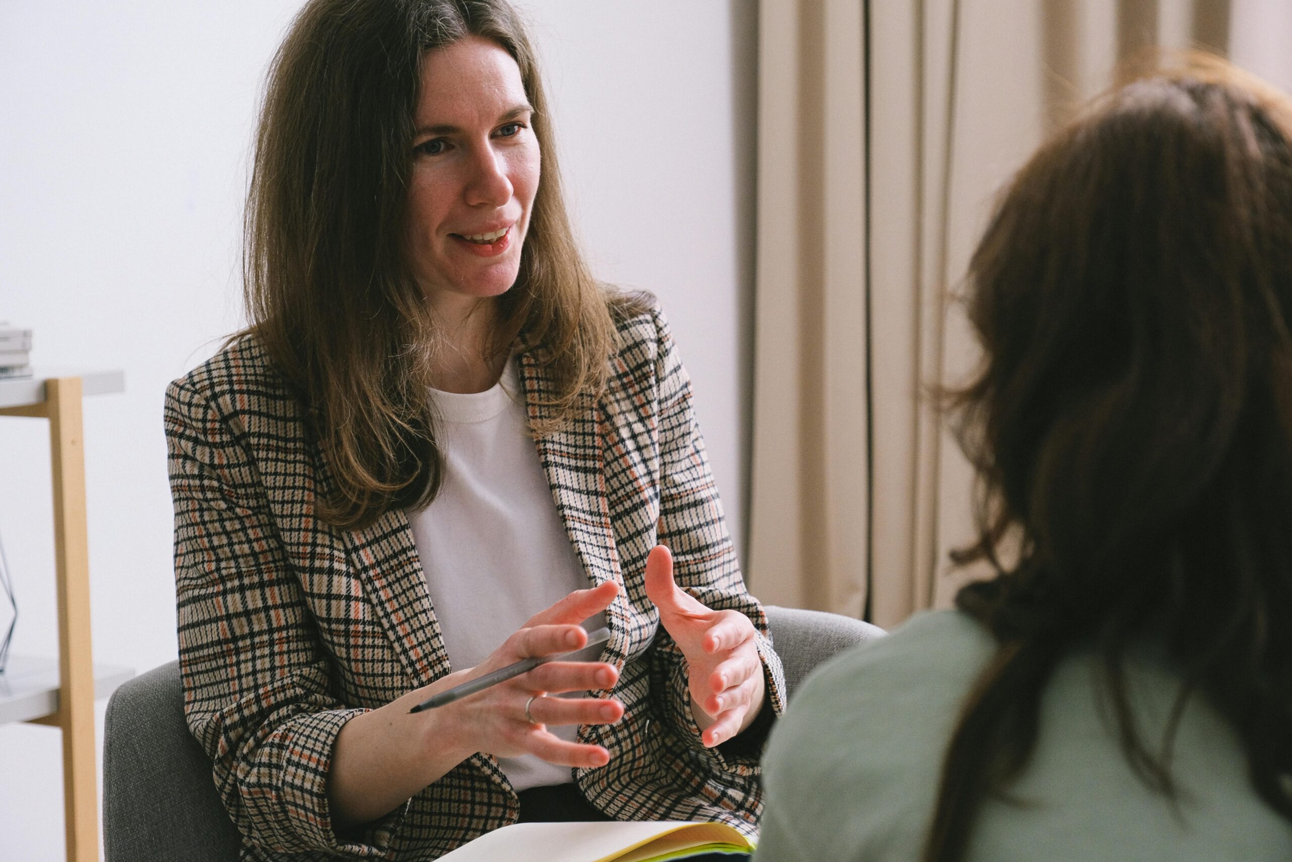 A warm therapist leaning in and talking with a client during a one-on-one session