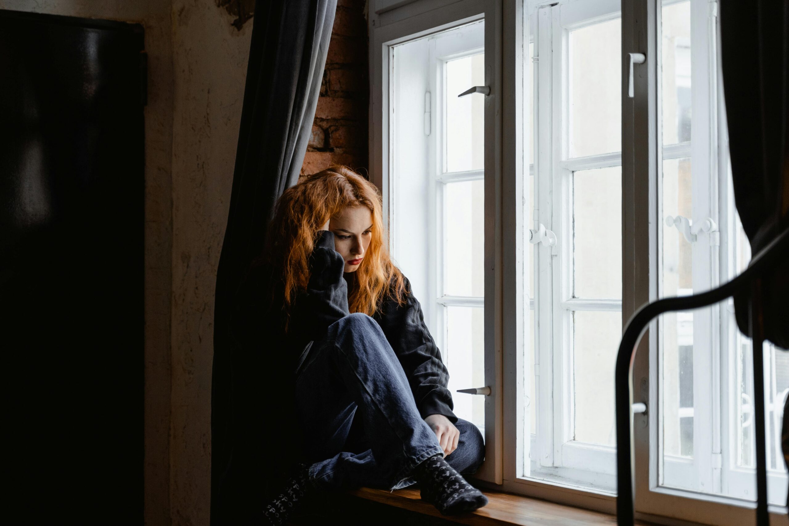 A person sitting quietly, weighed down by the heaviness of depression