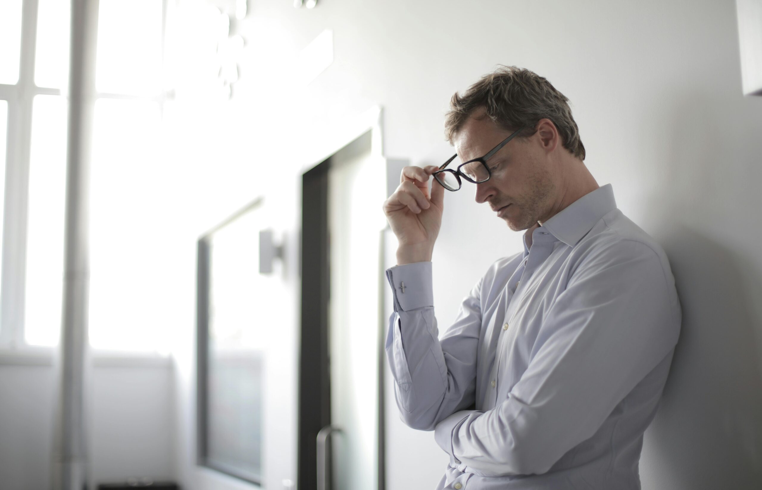 A person sitting alone with their head lowered, overwhelmed by intense emotion
