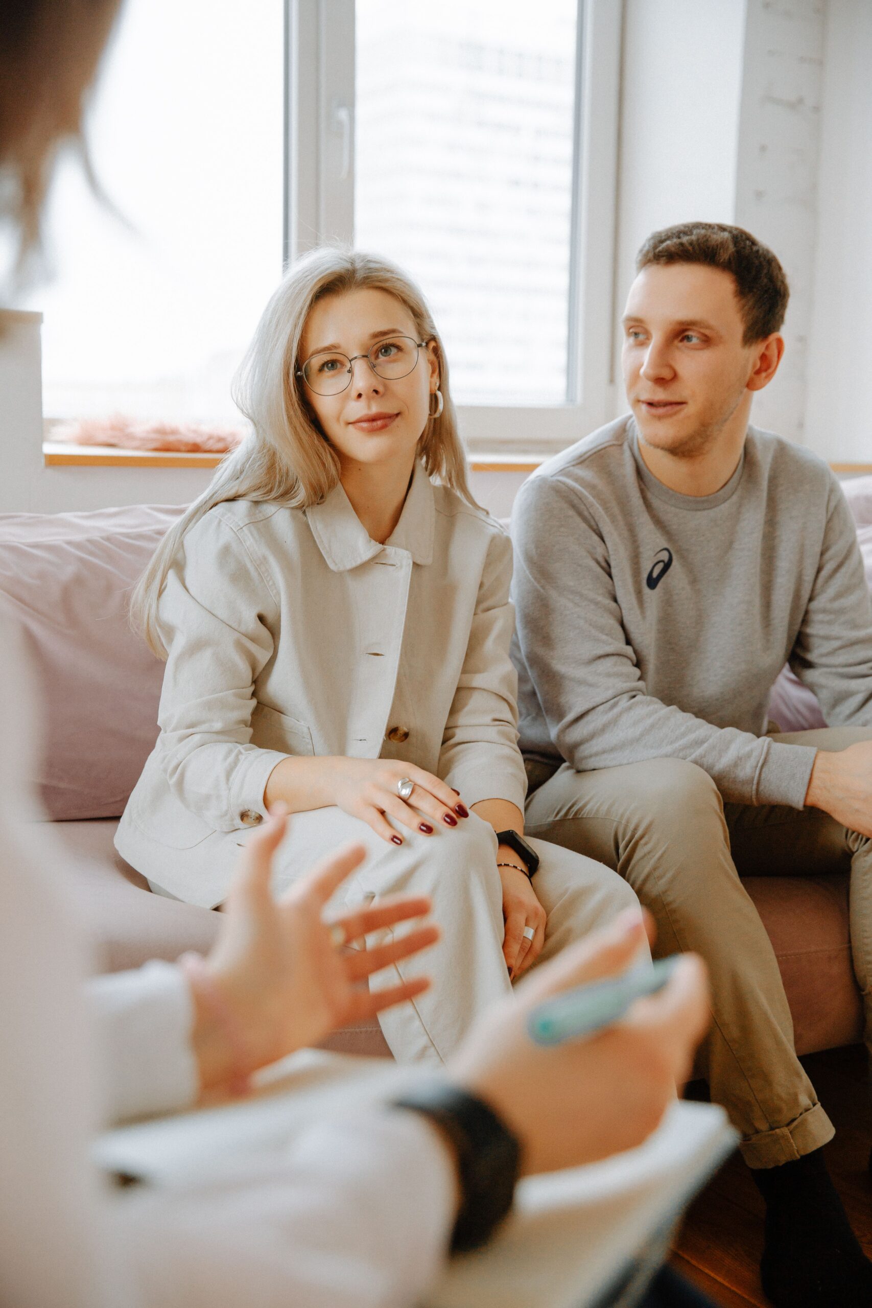 A couple sitting together during a therapy session, working through things side by side