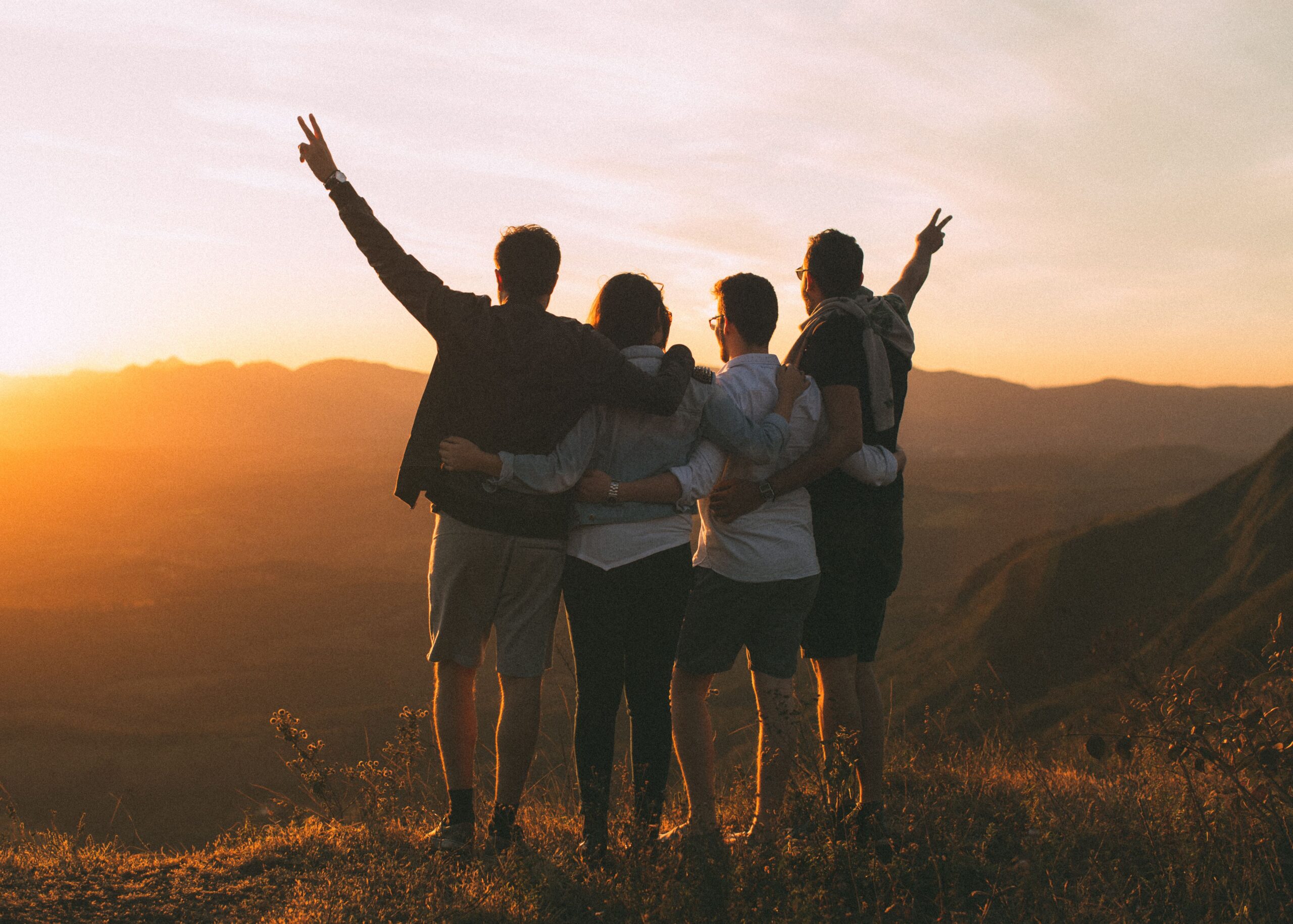 Four friends together at sunset, suggesting connection and relief after recovery.