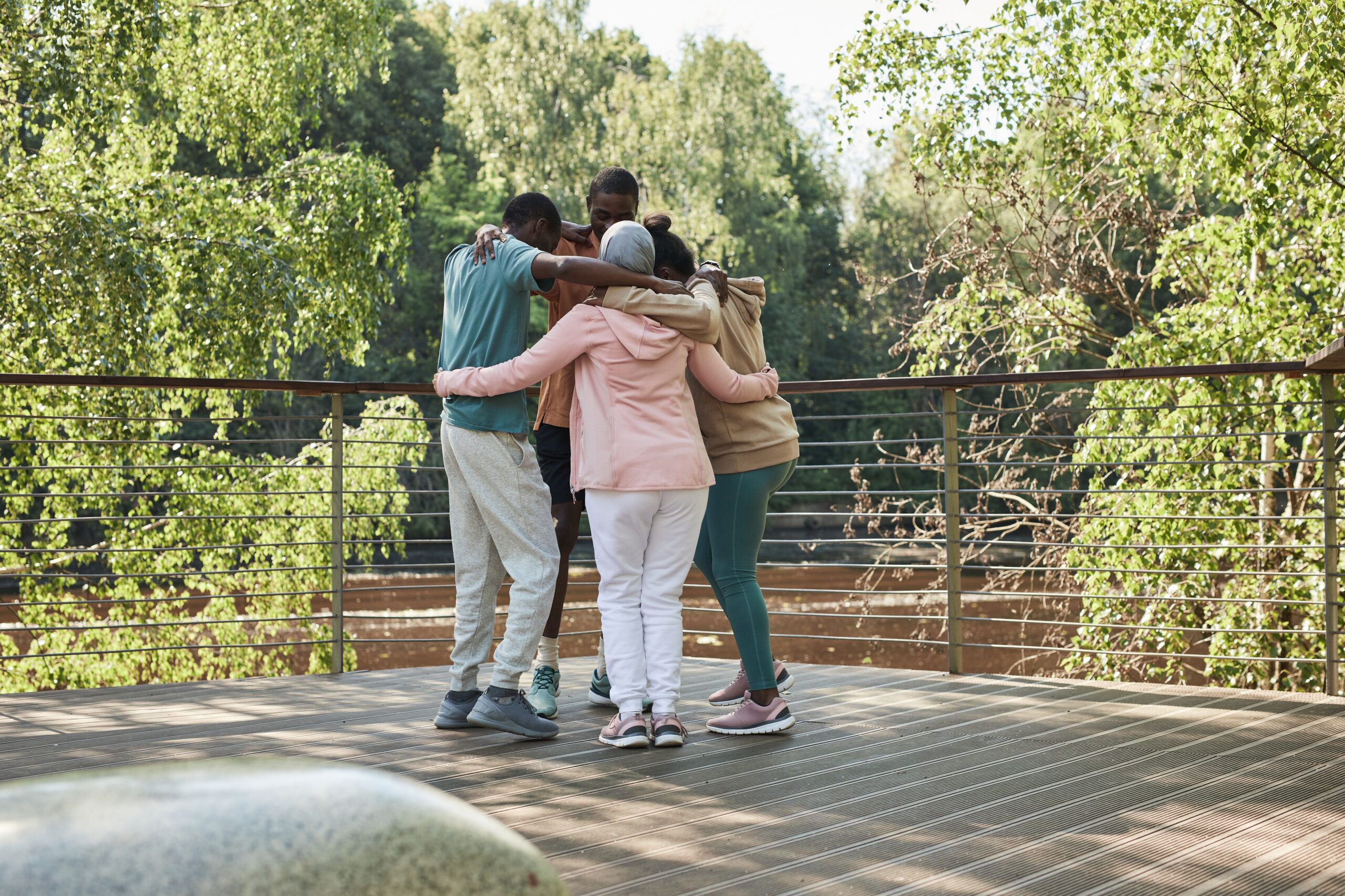 Group of people embracing in support outdoors