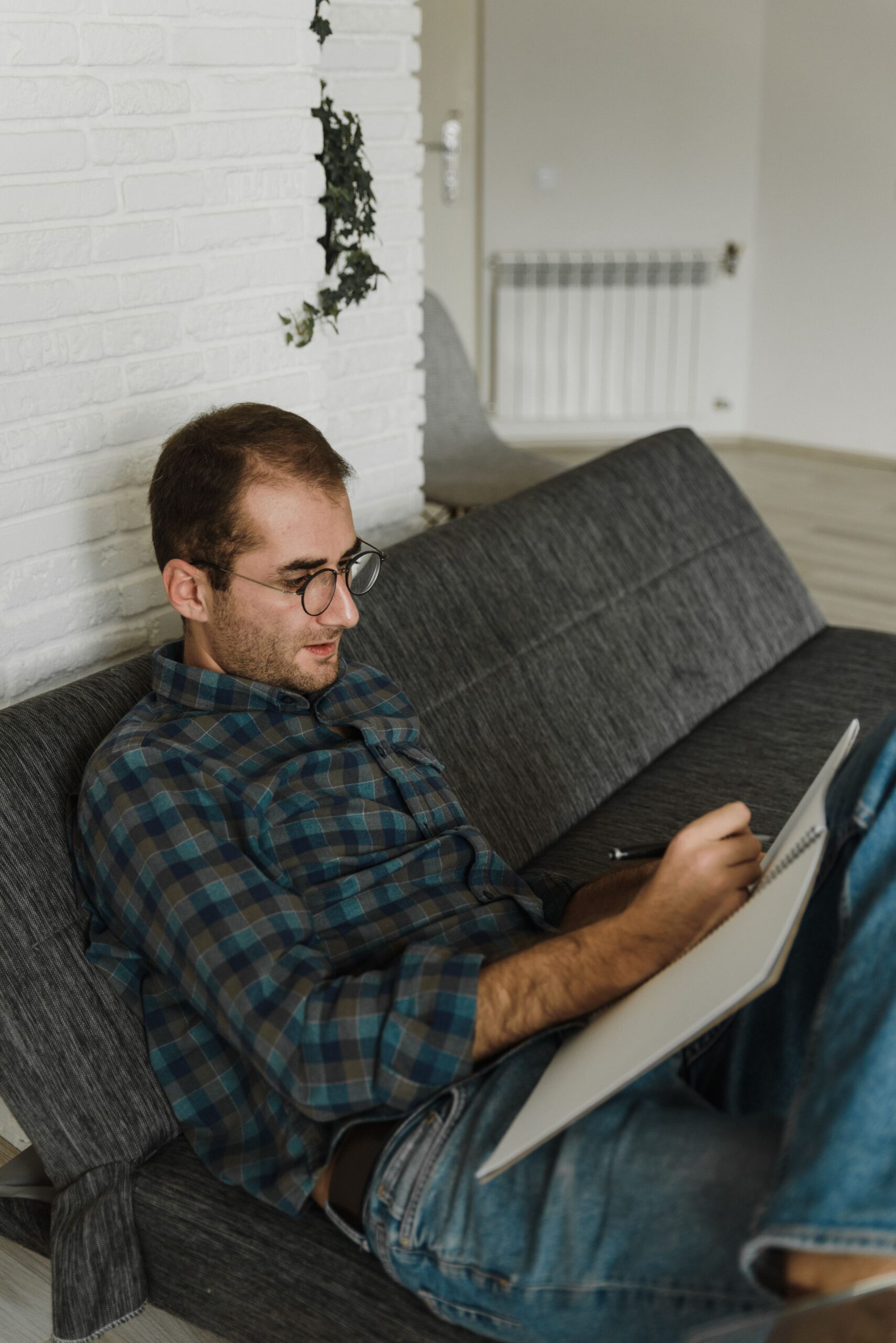 A man writing in a journal, reflecting before starting therapy
