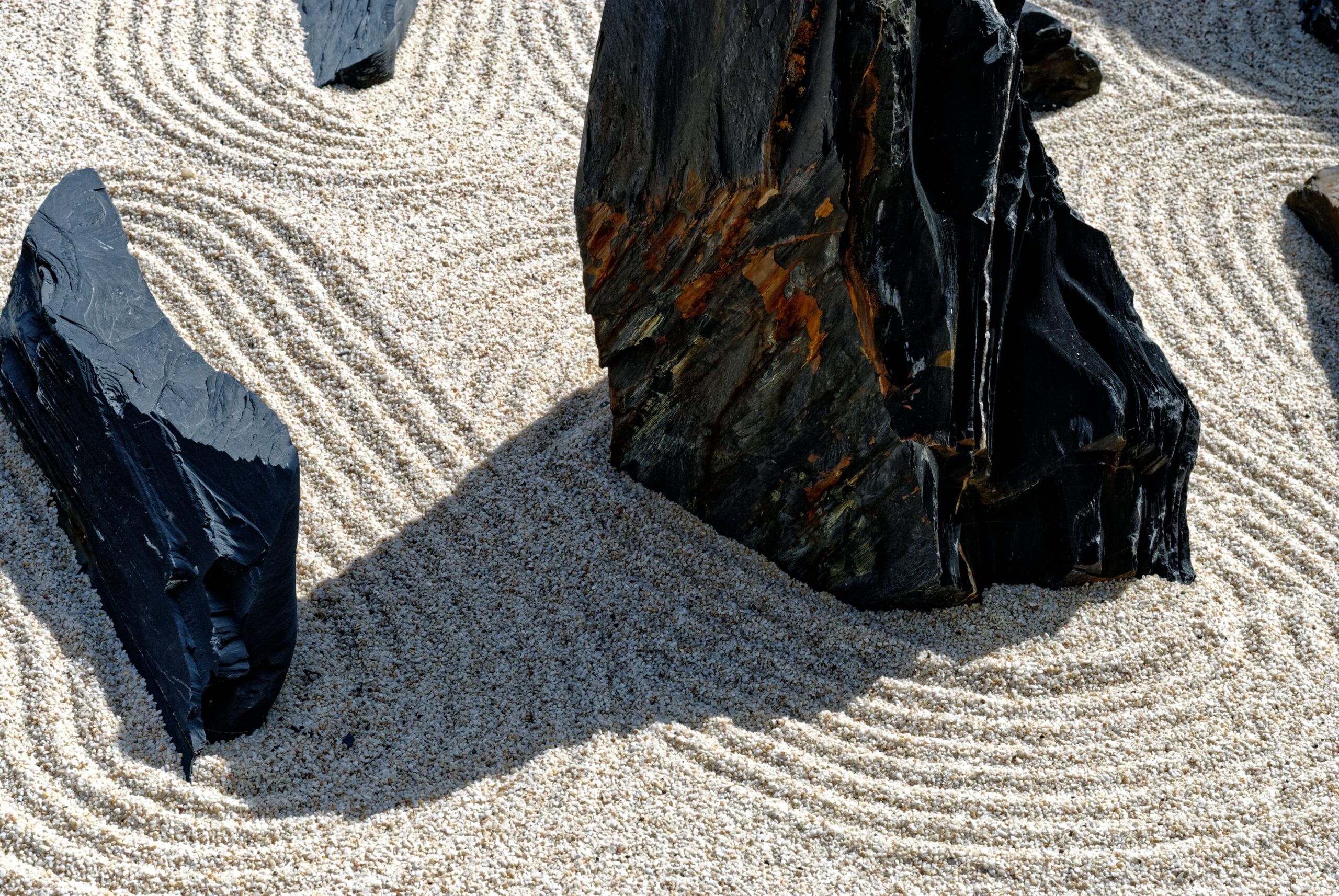 Smooth stones resting in sand, suggesting steadiness and calm.