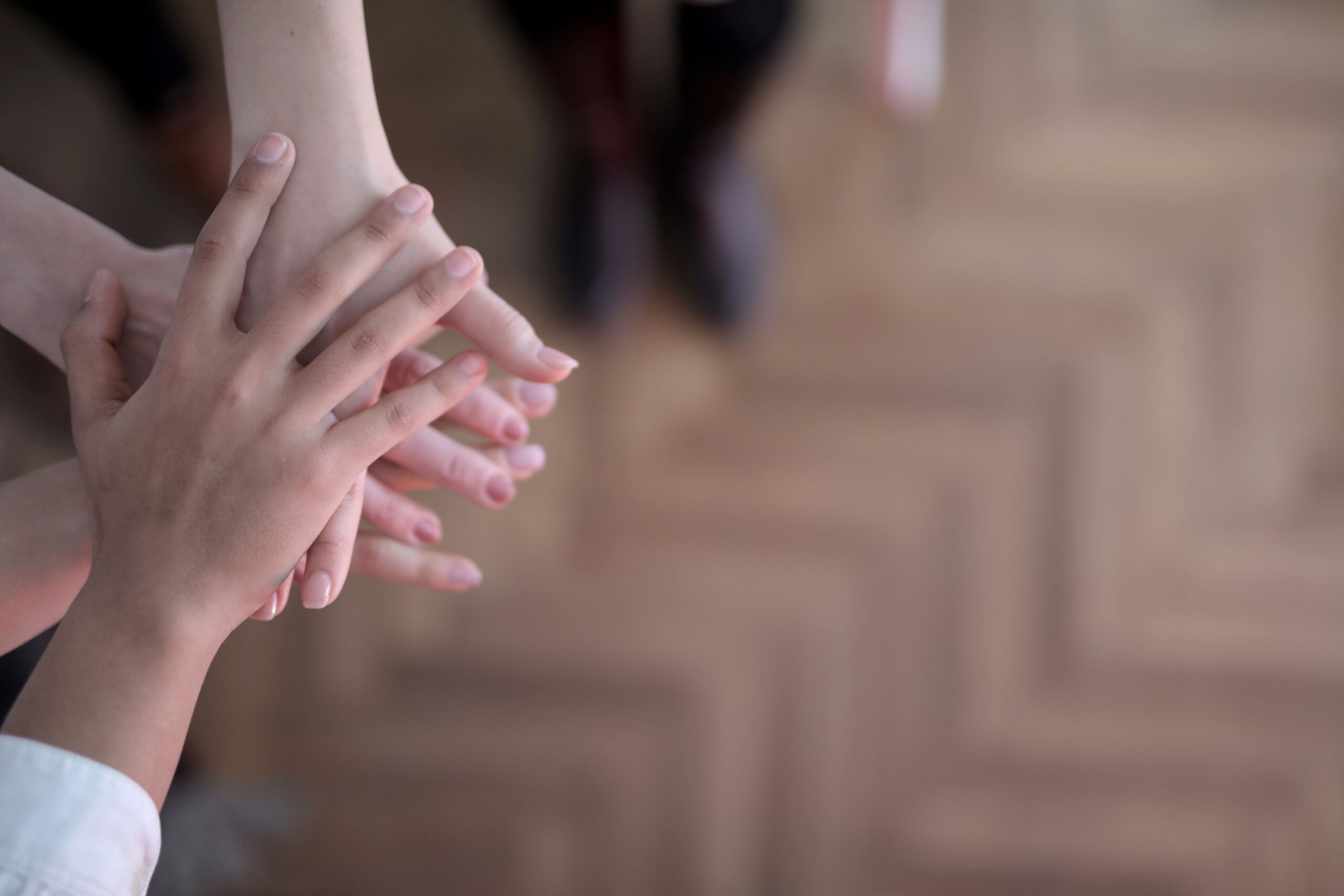Two people resting their hands together, representing a partner gently supported into the treatment process when the time is right